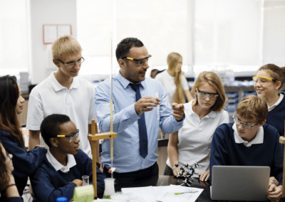 teacher describing something about science project to children in class